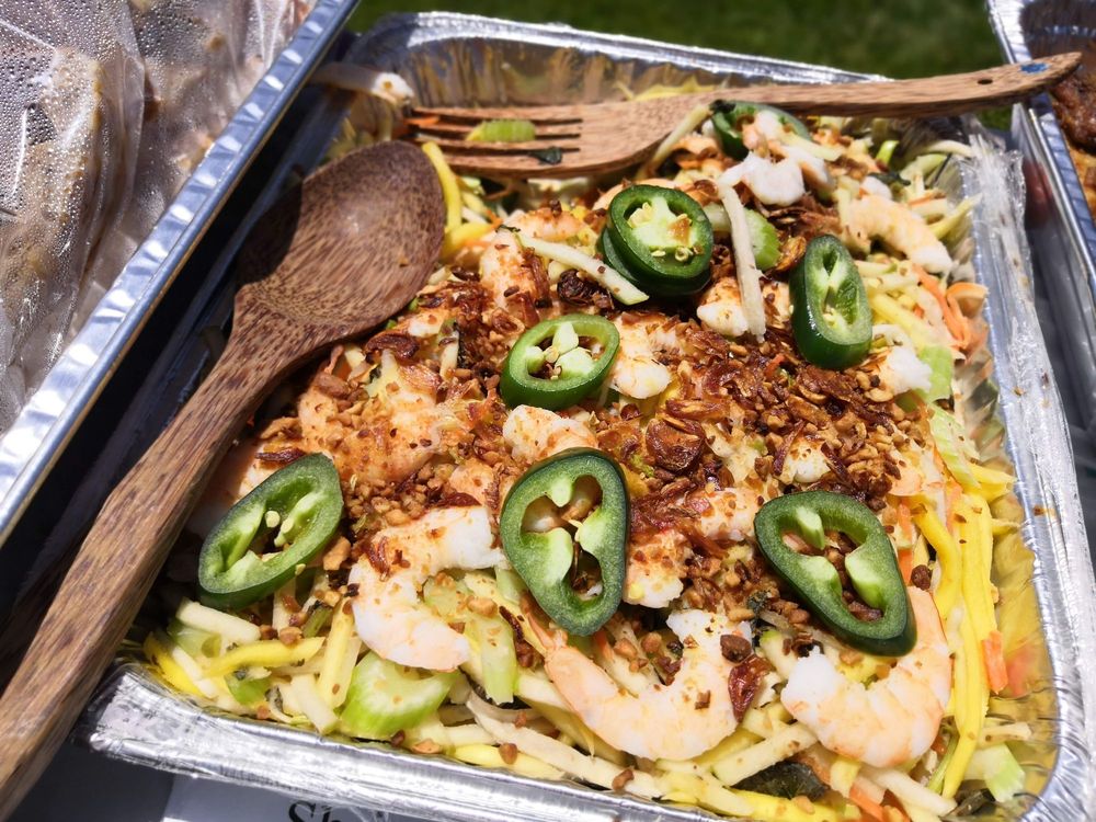 Vietnamese mango salad with shrimp and a wooden serving spoon and fork